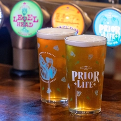Two glasses of Prior Life beer, on the bar.