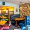 An interior restaurant seating area at the Counting House, with upholstered booth seats, and framed artwork on the walls.