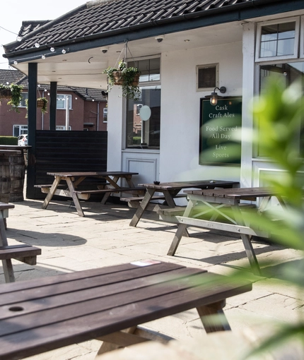 Exterior beer garden of a pub with a seating area.