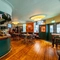 The bar and interior restaurant seating area at the Royal George; with wooden flooring, TVs on the walls, and a large wooden inlay picture of a sailing ship on the wall above the fireplace.