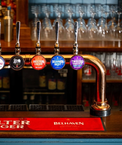 The interior bar focusing on a pump displaying pump clips including, Peroni, Belhaven Best, Twisted Thistle, Belter Lager, Tennents and St Mungo at the Armstongs. 