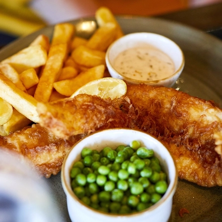 A plate of fish and chips on a table.