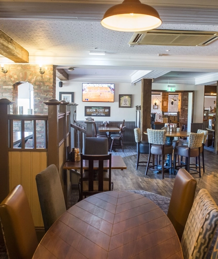 Interior dining area of a pub with a TV.