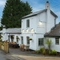 The exterior facade, signage, and seating area of The Fox & Hounds in Bursledon, with flower baskets hanging on the wall.