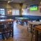 Interior dining area of a pub with a TV and a pool table.