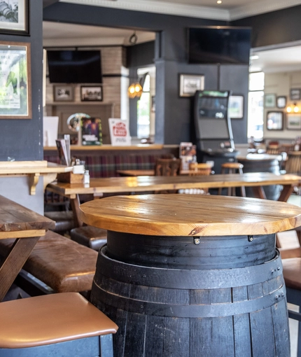 Interior dining area of a pub with a TV and gambling machines.