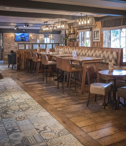 Interior dining area of a pub with a fireplace.