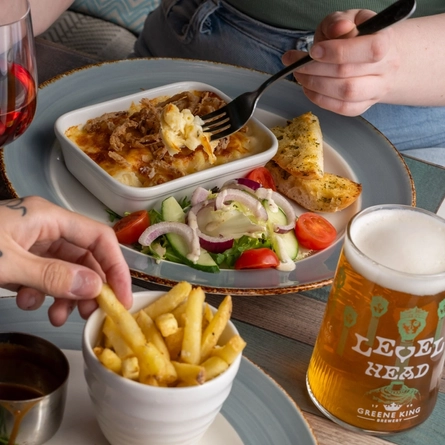 People seated at a table with plated food and drinks.