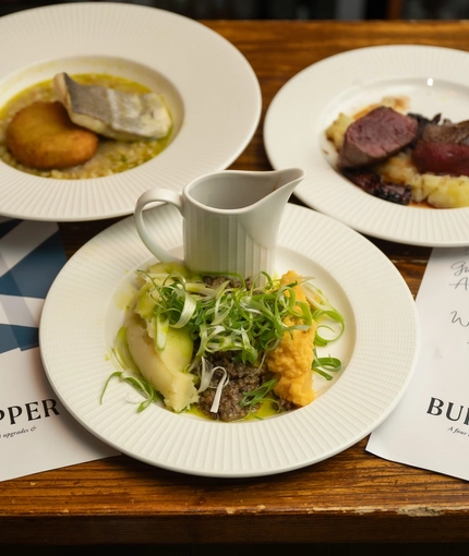An image of 3 plated Burns Night Main dishes sat on a table within the interior function room during a Burns Night Event at The Crabtree.