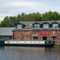 The exterior facade, signage, and waterside at The Stanley Ferry, with canal boats on the water in front of the venue.