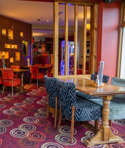 The interior restaurant seating area of The Royal Horse, with wooden tables and upholstered seats.