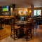 An interior restaurant seating area at the Rudds Arms in Marton-In-Cleveland; with TVs on the walls, and two illuminated dartboards.