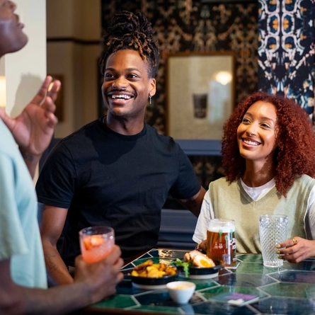 A selection of drinks and bar snacks being enjoyed within the interior restaurant and seating area at a Community Pubs with Food venue.