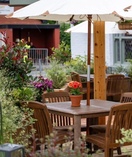 A table with an umbrella in the beer garden of the Grapes.