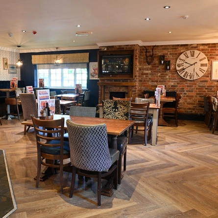 Interior dining area of a pub with a TV and a fireplace.