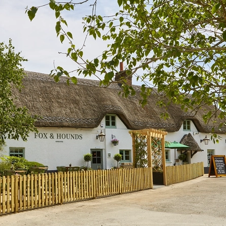 The exterior facade and beer garden seating area of The Fox & Hounds in Wimborne.