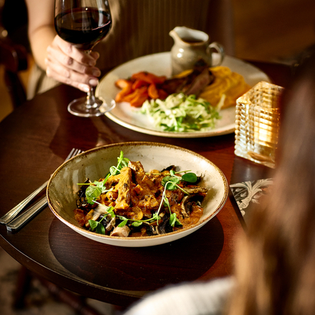An interior image of 2 customers with 2 Main Autumn Specials dishes available at Chef & Brewer venues.