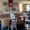 An interior restaurant seating area at Whitehills, with an upholstered booth seat, framed photographs on the wall, and a pub gaming machine.