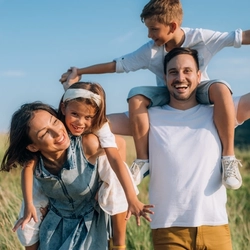 A mother and father with their children on their backs, laughing.