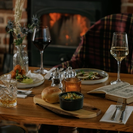 An advertising image of 3 starter dishes from the Burns Night menu sat on a table within the interior restaurant seating area at The Crown.